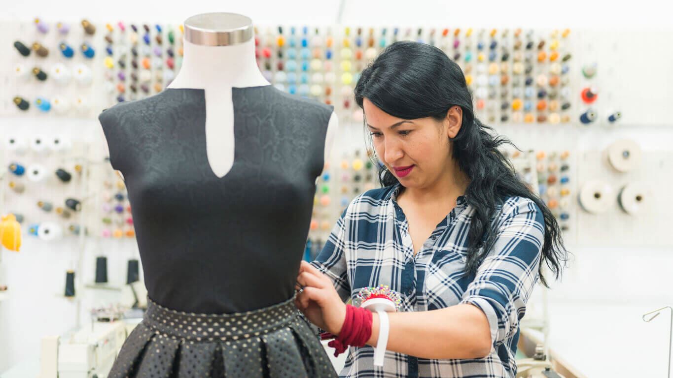 Seamstress working on a dress on a mannequin